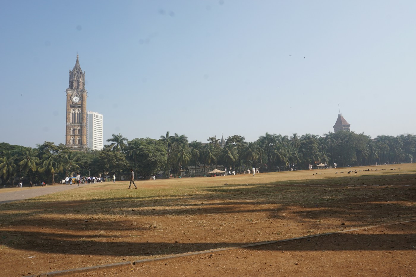 Open cricket ground with a clock tower in Mumbai